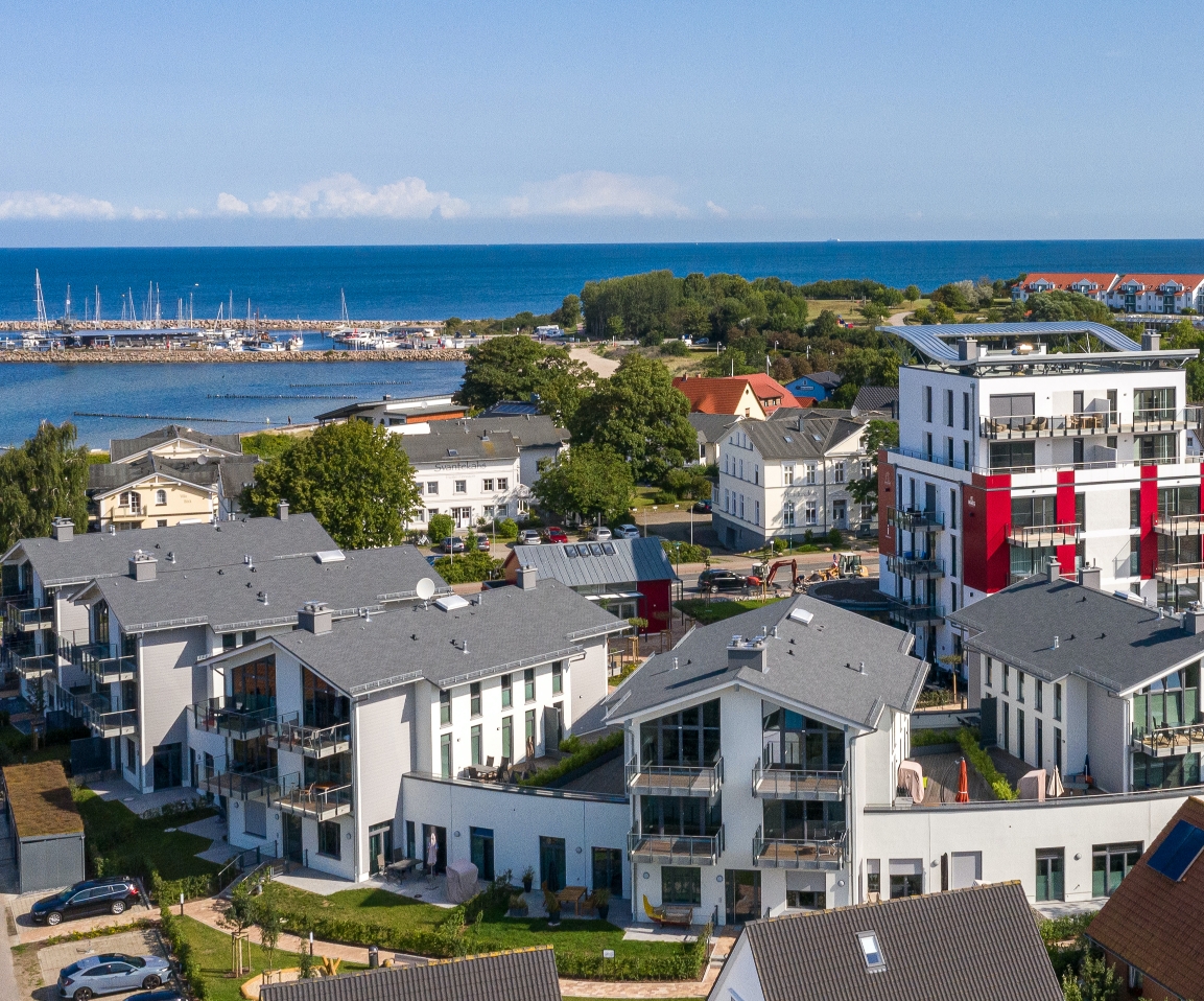Sandstrand mit Dünen und Strandkörben, Personen genießen den sonnigen Tag und das Meer